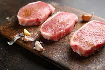 Uncooked meats on wooden board