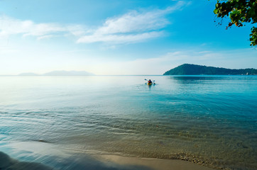 Early morning, the kayak sails to the island. Tourists go kayaking off the coast of Koh Chang, Thailand