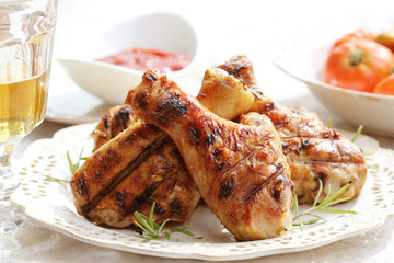 Grilled chicken legs with rosemary on table