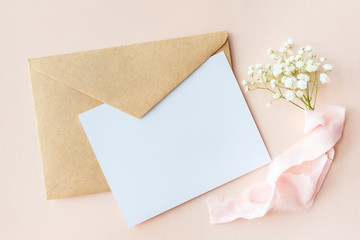 A letter on a pink background with Gypsophila with silk ribbon, invitation for a wedding, a text...