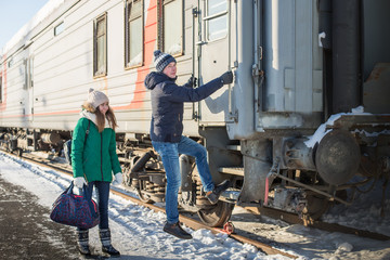 Couple at railway station near train in a winter time
