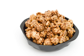 Photo of chocolate popcorn in black bowl on white background.