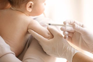 Obraz na płótnie Canvas Doctor vaccinating baby in clinic, closeup