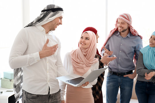 Muslim office employees in traditional clothes having business meeting indoors