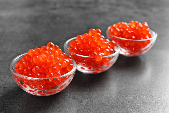 Glass bowls with delicious red caviar on table