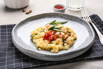 Plate with tasty shrimps and grits on table