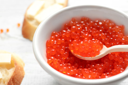 Bowl and spoon with red caviar, closeup