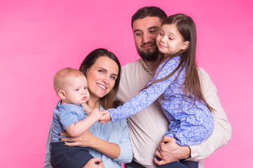 Happy mixed race family portrait smiling on pink background