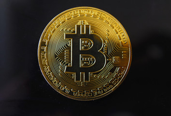 Gold souvenir coin Bitcoin on a black background.