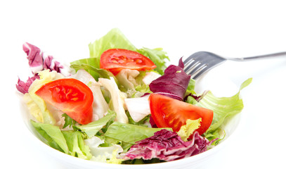 Close-up of a salad mix of fresh green leaves frieze, radicchio, endive and tomato. Dietary vegetable menu.