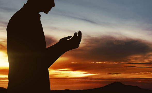 Silhouette of muslim man praying