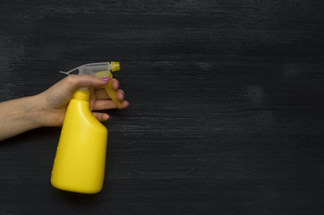Hand with sprayer bottle sprinkles water abstract background with copy space. Top view, flat layer.