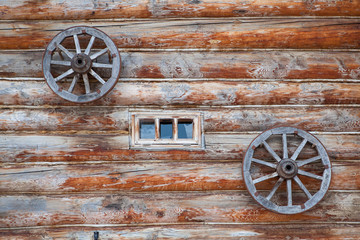 Obraz premium Old farm house wooden wall and wagon wheels