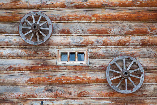 Old farm house wooden wall and wagon wheels