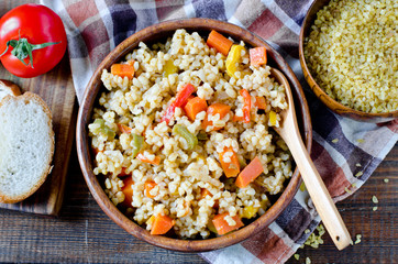 Porridge from bulgur with vegetables: carrots, bell peppers, onions, zucchini
