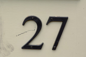 Naklejka premium House number 27 sign on wooden door