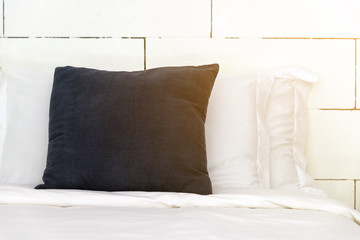 stacking of blue backrest pillow and white pillow on bed and white brick wall, interior modern bedroom