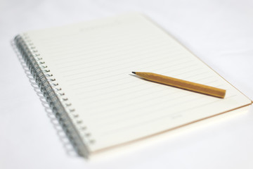 Small pencil on blank notebook, to do list, reminder.