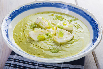 Crema o sopa de calabacín con manzana y cebolleta y queso mozzarella aderezada con aceite de oliva virgen extra para una dieta vegetariana y saludable