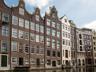 Fototapeta premium Typical gabled houses on Damrak street in Amsterdam, Holland, Netherlands