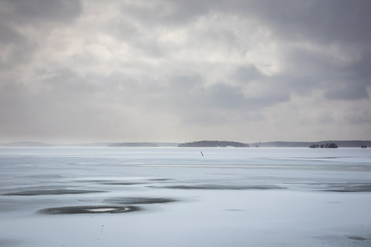 Beautiful winter seacape with hazy clouds and frozen sea.