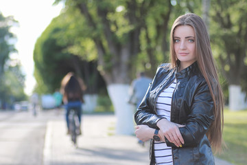 Young girl on a walk. Girl in a leather jacket on the street. Be