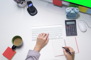 Business woman hand working on computer keyboard view from top.Woman's hand holding pen and keyboard at office desk.