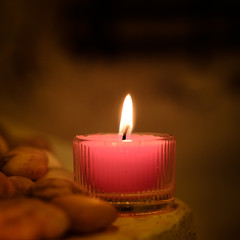 Prayer and hope concept. Retro pink candle light and old stone with lighting effect and glitter abstract background with bokeh defocused lights