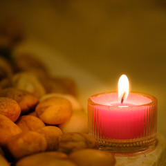 Prayer and hope concept. Retro pink candle light and old stone with lighting effect and glitter abstract background with bokeh defocused lights
