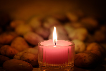 Prayer and hope concept. Retro pink candle light and old stone with lighting effect and glitter abstract background with bokeh defocused lights