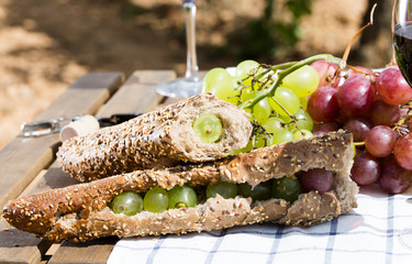 sandwich with green grapes on table in vineyard