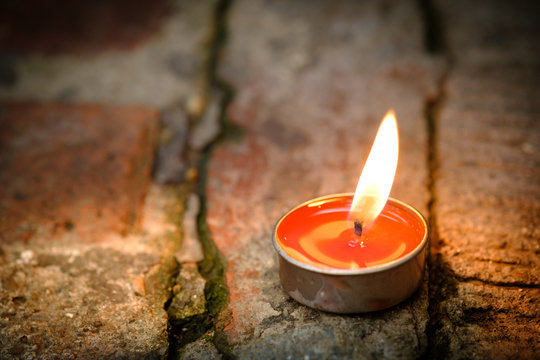 Prayer and hope concept.Candle flame light at night with abstract circular bokeh background