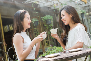 Two woman meet in coffee shop talk without use smartphone