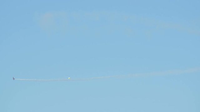 Plane and a parachute jumper flying on the sky