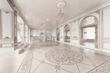 Luxurious vintage interior with fireplace in the aristocratic style. Large Windows and mirrors....