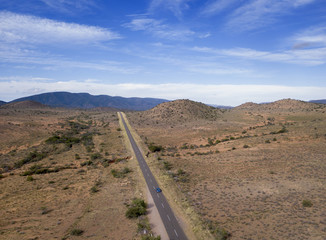 Aerial of long road in arid landscape