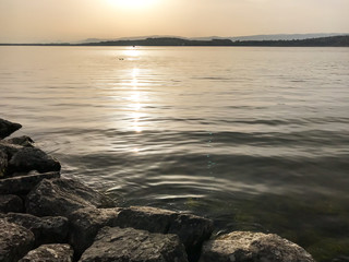 evening sun and light over lake with reflections and peaceful ripples in Lake Murten in Switzerland