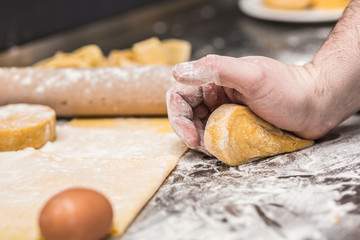 Fototapeta na wymiar The chef's hands prepare dough for pasta