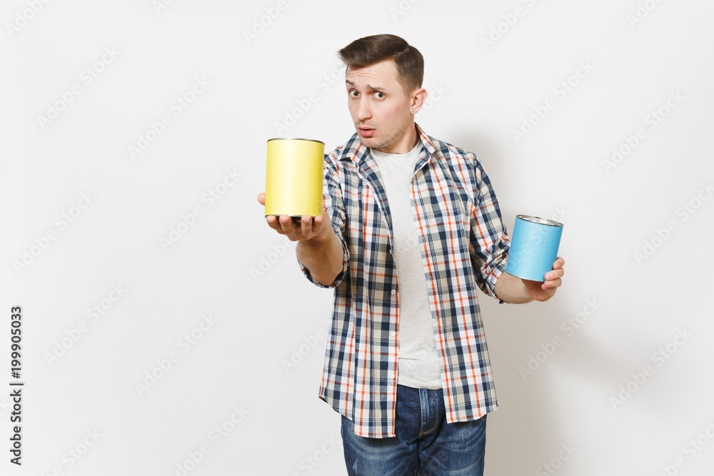 Wall mural young concerned handsome man in casual clothes pointing empty paint tin can with copy space on camer