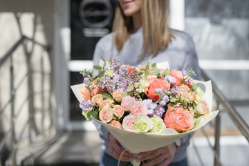 bouquet of beautiful flowers in women's hands. Floristry concept. Spring colors. the work of the florist at a flower shop