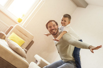 Father and son playing together and having fun in living room