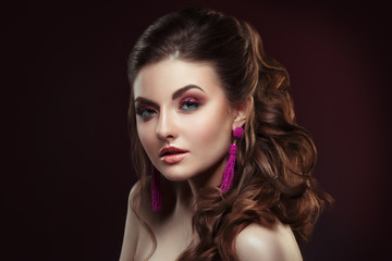Fashion beauty portrait of a beautiful girl with a bright make-up and an elegant hairstyle on a dark background.