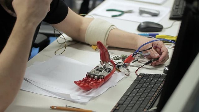 Male professional testing bionic hand on the table. Concept: people, bionic, technology, biology body