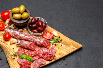 Dried organic salami sausage on wooden cutting board