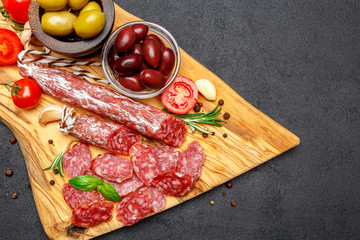 Dried organic salami sausage on wooden cutting board