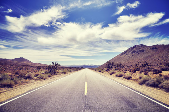 Vintage stylized picture of a deserted road, travel concept, California, USA.