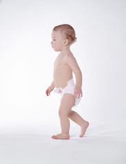 Naked baby walking at studio shot