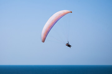 Tandem paragliding above mediterranean sea on blue sky background