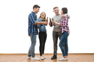 The four happy friends drink a beer on a white wall background