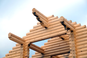 Top of rural wooden house from sandy brown smooth planed heavy pine logs in construction process side view